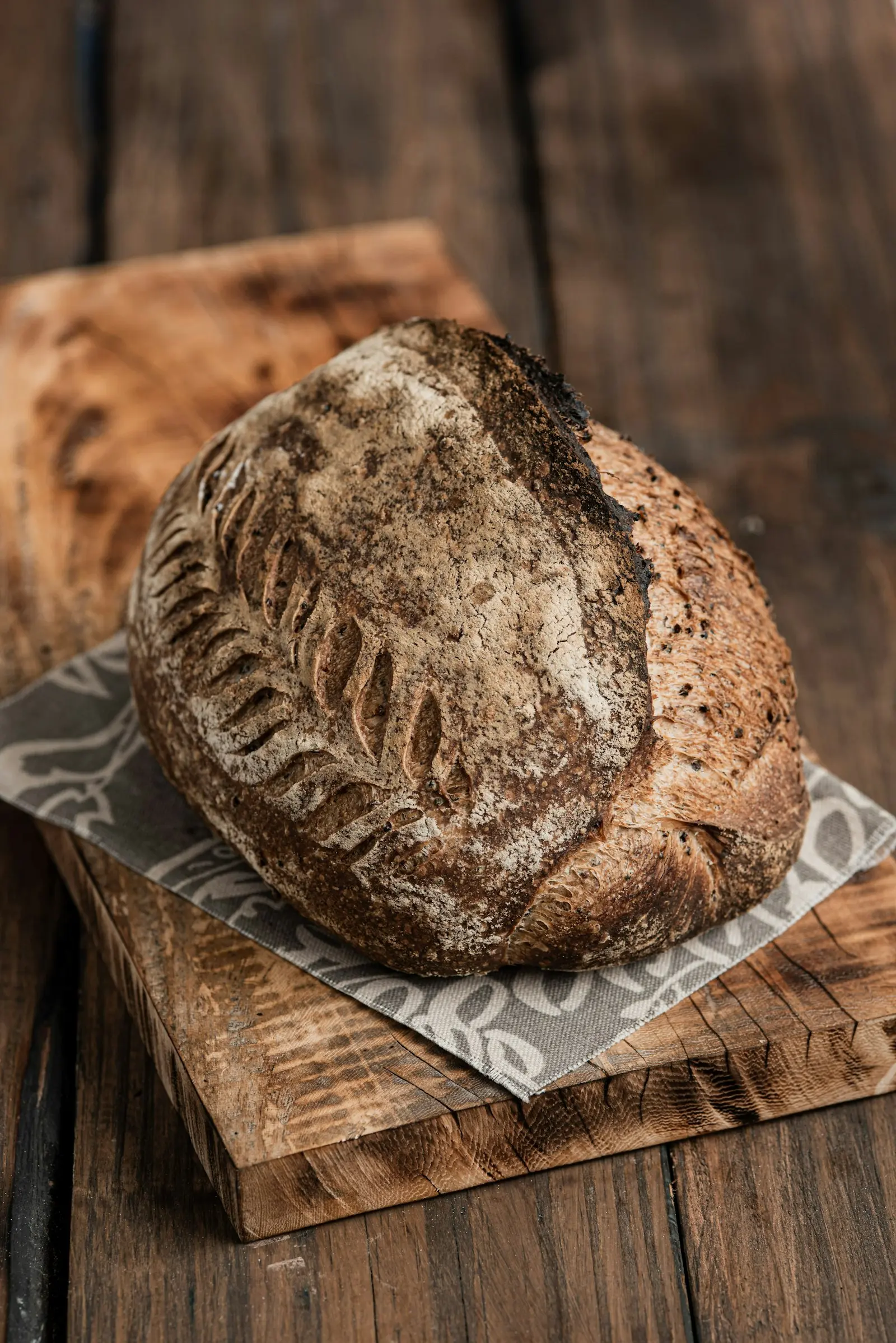 Pagnotta artigianale con crosta incisa e farina